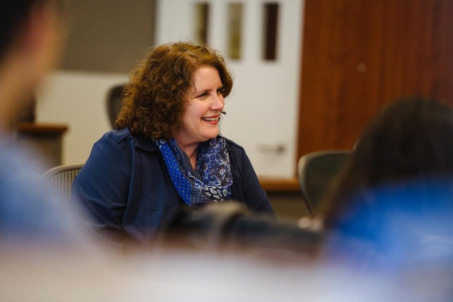 Photo of a woman speaking to other faculty members.