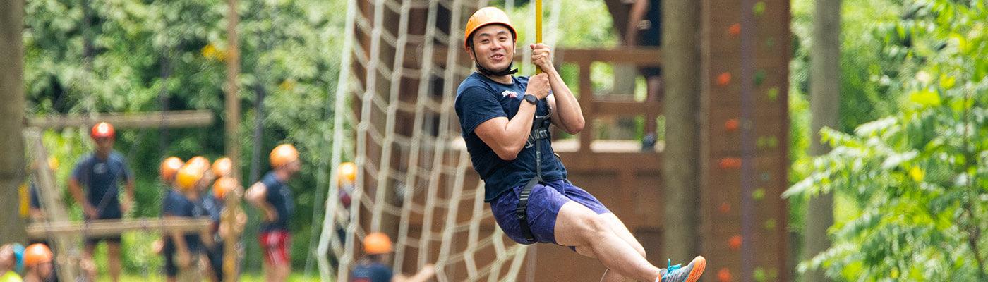 MBA student riding zipline during BaseCamp Team Day