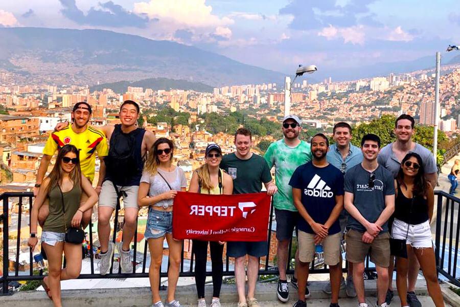 A group of Tepper students in Colombia, holding Tepper flag.