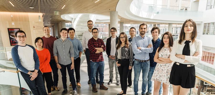 image of group of diverse phd students standing in glass atrium of tepper quad